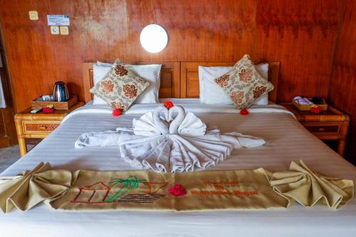 a bedroom with a bed with towels on it at Amed Cafe & Hotel Kebun Wayan in Amed