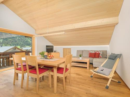 a dining room with a table and chairs and a couch at Felder Apartments in Schoppernau