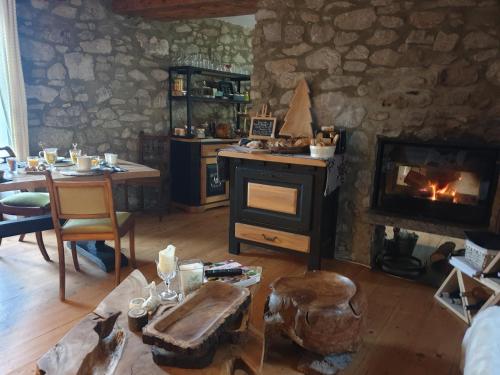 a living room with a stove and a table and a fireplace at La Petite Chapelle in Font-Romeu