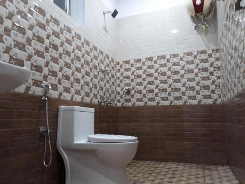 baño con aseo y pared de azulejos en Aden Valley, kanthalloor, en Kanthalloor