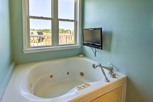 een badkamer met een bad, een raam en een tv bij Charming Waterfront Home Fish, Boat and More! in Sneads Ferry