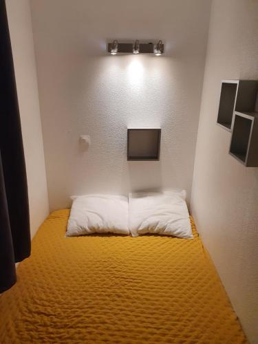 Cette petite chambre comprend un lit avec une couverture jaune. dans l'établissement Studio cabine Arzon Crouesty 4p, à Arzon