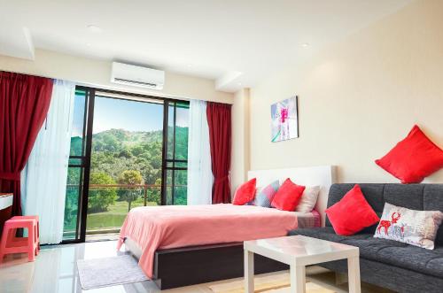 een slaapkamer met een bank en een bed met rode kussens bij Nai Thon Condo Unit in Nai Thon Beach