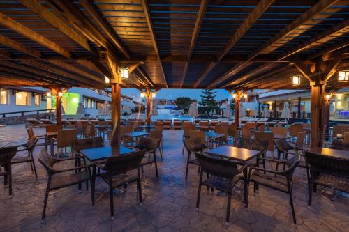 a restaurant with tables and chairs and lights at Gaia Village in Tigaki