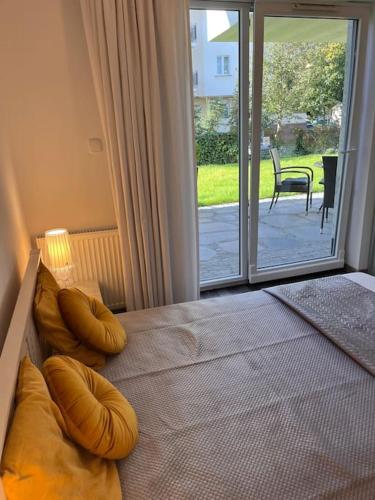 sypialnia z łóżkiem i przesuwanymi szklanymi drzwiami w obiekcie Apartament Stella Baltic w Świnoujściu