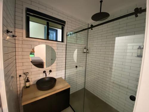 a bathroom with a black sink and a mirror at Kosmo’s Studio: City Style in a Retreat Setting! in Boyland