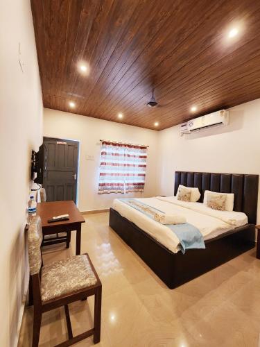 a bedroom with a large bed and a wooden ceiling at Garden Villa in Vagator