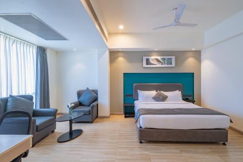 a hotel room with a bed and a chair at REPUBLIC INN in Tirupati