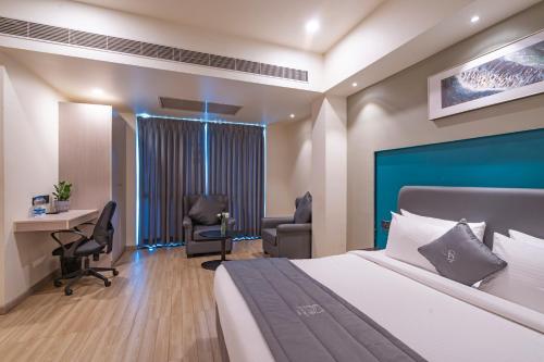 a hotel room with a bed and two chairs and a desk at REPUBLIC INN in Tirupati