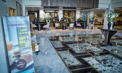 a lobby with glass floors and tables and chairs at IFQ Hotel & Resort in Islamabad