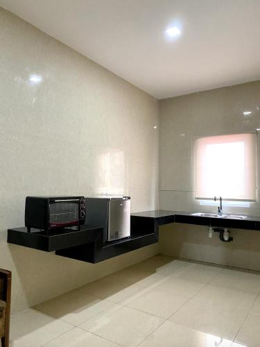 a kitchen with a microwave and a sink at Hans Inn Batam in Nagoya