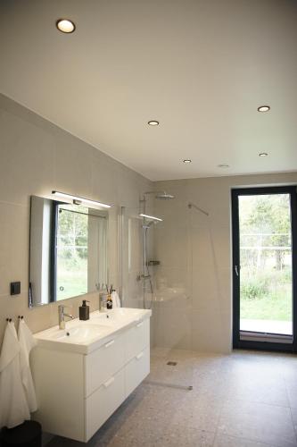 a white bathroom with a sink and a shower at Maasika Villa 
