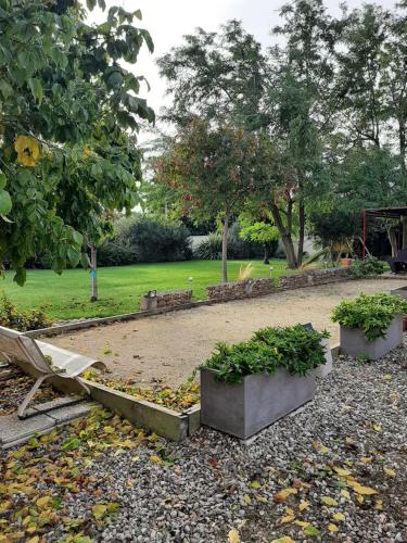 a park with a bench and some plants at Tranquillité B&B in Cuxac-dʼAude