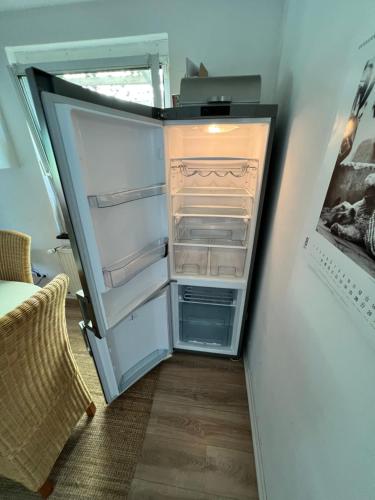 an empty refrigerator with its door open in a room at Ferienlandhaus Riehenhaar in Telgte