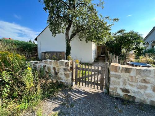 a fence with a tree in front of a house at Ferienlandhaus Riehenhaar in Telgte