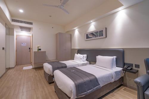 a hotel room with two beds and a door at REPUBLIC INN in Tirupati