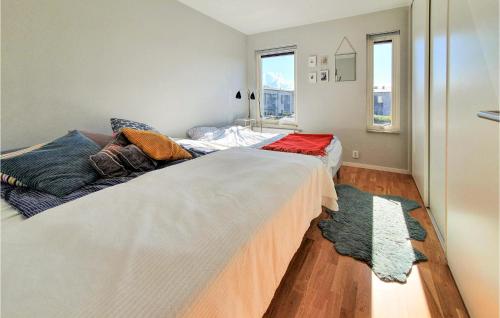 4 Bedroom Nice Home In Limhamn في مالمو: سريرين يجلسون بجانب بعض في غرفة