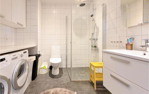 4 Bedroom Nice Home In Limhamn في مالمو: حمام مع غسالة ملابس ودش