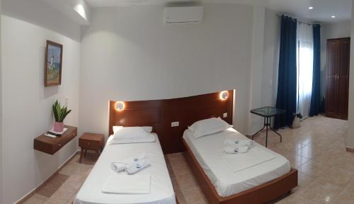 a bedroom with two beds with white sheets at Kasos Palace in Frý