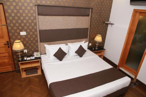 a bedroom with a large bed with two night stands at Lawrence View Hotel, Lahore in Lahore