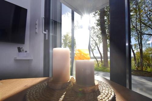 two candles sitting on a table in front of a window at Gwiazda Kaszub in Chmielno