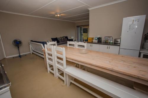 スウェレンダムにあるAppelsbosch Guest Farmのキッチン(長い木製テーブル、白い椅子付)