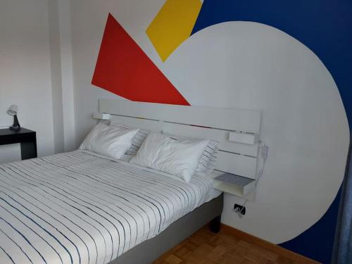 a bedroom with a bed and a colorful wall at Casina 2 quadrati, vista collina in Moncalieri