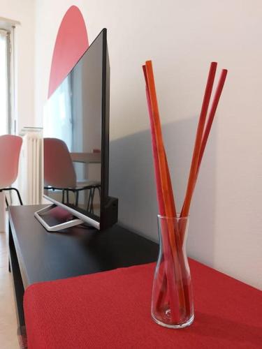 a vase with sticks in it on a table with a mirror at Casina 2 quadrati, vista collina in Moncalieri