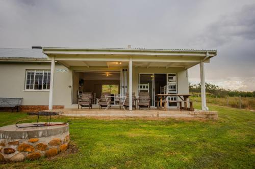 a house with a patio with a table and chairs at Appelsbosch Guest Farm in Swellendam