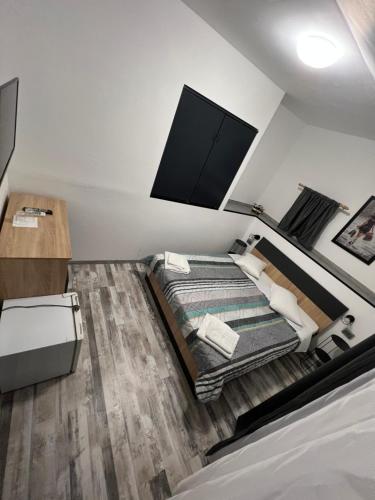 a bedroom with a bed with a flat screen tv on the wall at Pensiunea Luisa in Craiova