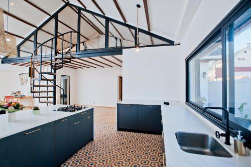 a kitchen with black cabinets and a large window at Joyau secret # Jardin # Piscine # Bien-être # prox centre ville in Antananarivo