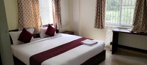 a bedroom with a large white bed with red pillows at Hotel Bangalore Airport Inn, Near kempegowda Airport, Airport Pickup & Drop Available 24X7 in Bengaluru