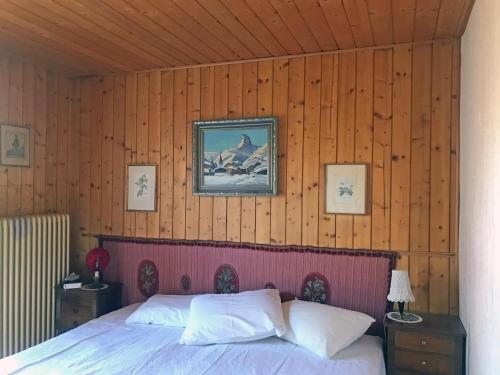 a bedroom with a bed in a wooden wall at Les Tchaipus in Nendaz