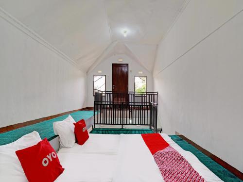 a room with a bed with red pillows on it at Super OYO Capital O 91810 Hotel Balebat 2 in Bandung