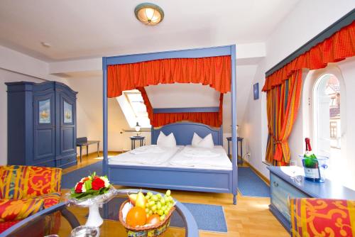 a bedroom with a bed and a table with a bowl of fruit at U-Nautic Restaurant & Pension in Waren