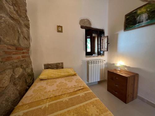 a bedroom with a bed and a dresser and a window at Abruzzo Borgo in Alanno