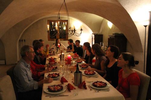 a group of people sitting at a long table with food at Chalet Solneige in Vaujany
