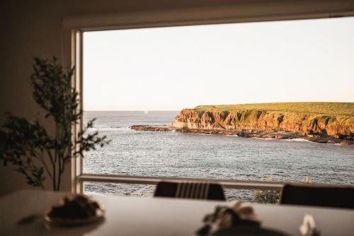 a view of the ocean from a window at 42 Loves Bay 5 Bedroom Sea cliff View House with Pool in Kiama
