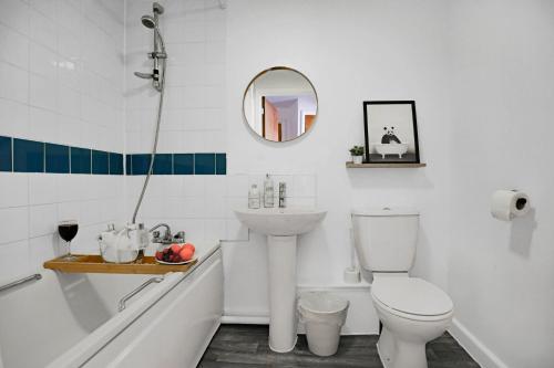 a bathroom with a toilet and a sink and a bath tub at City Centre Apartment with Free Parking, Balcony, Super-Fast Wifi and Smart TV with Netflix by Yoko Property in Northampton