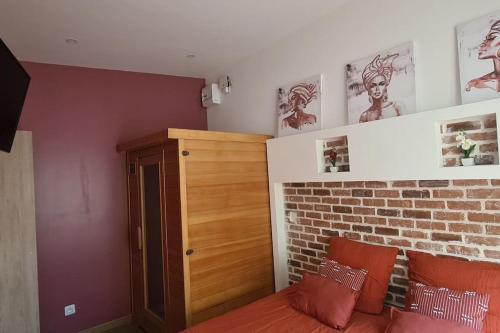 a bedroom with a bed and a brick wall at Charmant studio climatisé avec Sauna in Le Bois de Nèfles