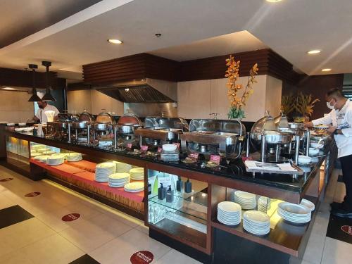 a chef in a kitchen preparing food in a restaurant at Tara Mantra Cha-Am Resort in Cha Am