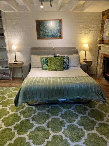 a bedroom with a large bed with two lamps and a fireplace at Lakeview On Sycamore in Emerald