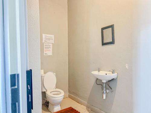 a bathroom with a toilet and a sink at Akani Guest House in White River