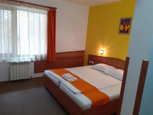 a bedroom with a bed and a large window at Hotel Les in Razgrad