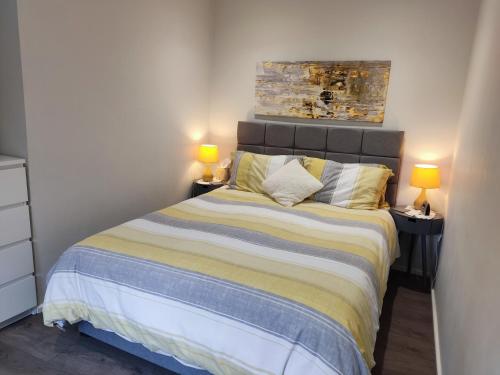 a bedroom with a bed with two lamps on tables at Little Ings, Modern, idyllic hideaway in Yorkshire market town in Easingwold