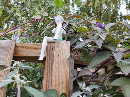 a statue of a woman sitting on top of a wooden fence at Little Ings, Modern, idyllic, self-contained hideaway in Easingwold, North Yorkshire in Easingwold