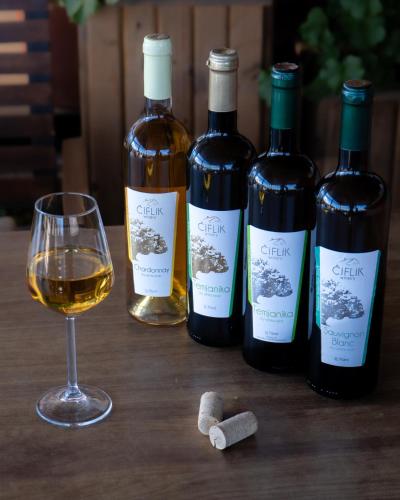 a group of three bottles of wine and a glass at Ciflik Winery in Bitola