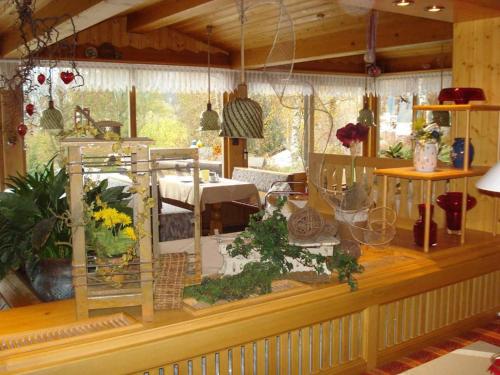 ツヴィーゼルにあるPension Einsiedeleiの植物の置かれたカウンターとテーブルが備わる部屋
