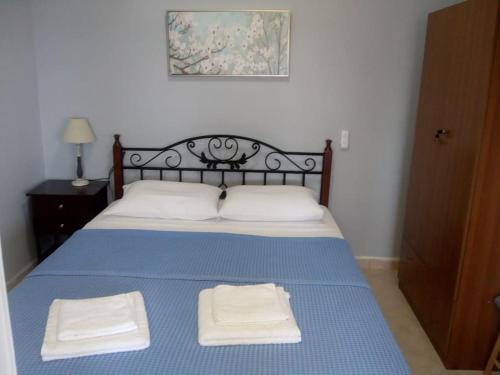 a bed with two white towels on top of it at Kamares View in Ayeranós