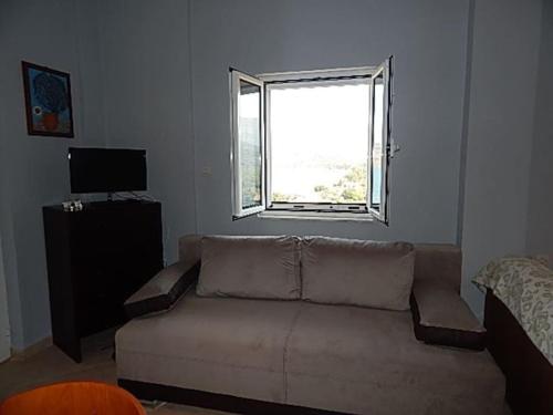 a living room with a couch and a window at Kamares View in Ayeranós